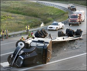 Crews work on an overturned tractor-trailer on the I-280 entrance ramp to the east bound lanes of the Ohio Turnpike Thursday, near Stony Ridge, Ohio.