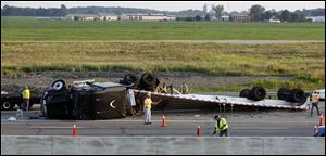 Crews work on an overturned tractor-trailer.