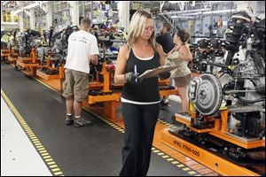Chrysler Group employees work on the new Cherokee line at the Jeep Assembly complex in Toledo. Production of the new model began June 24, and workers eventually will be able to produce 896 vehicles a day.