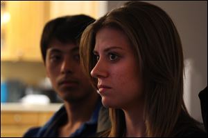 Aurora, Colo. theater shooting survivors Eugene Han, left, and his fiancee Kirstin Davis sit together during an interview inside a family home in Aurora.