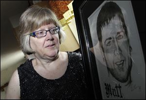 Jerri Jackson, mother of Aurora, Colo. theater shooting victim Matthew McQuinn, stands next to a sketch of her son in Springfield, Ohio.