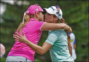 Paula Creamer, left, hugs Beatriz Recari after they finished the 18th hole. Creamer and Recari are tied for the lead going into today.