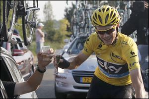 Christopher Froome of Britain, wearing the overall leader's yellow jersey, toasts with his team director during the 21st and last stage of the Tour de France that he later won.