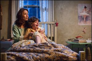 In this publicity image released by Warner Bros. Pictures, Lili Taylor portrays Carolyn Perron, left, and Joey King portrays Christine in a scene from 