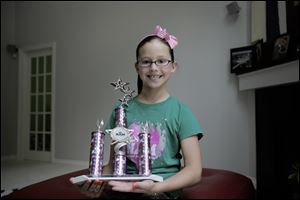 Laci MacQuisten, 9,  of Temper-ance took home a large trophy from the Michigan pageant and qualified for the national pageant in Anaheim, Calif., in November.