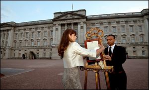 At Buckingham Palace, Ailsa Anderson, the queen's press secretary, with Badar Azim, a footman, places the official announcement of the birth of the third-in-line to the throne. 