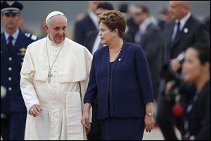 Brazil's President Dilma Rousseff walks alongside Pope Francis upon his arrival at the international airport in Rio de Janeiro, Brazil, today in his first trip as pontiff to Latin America.