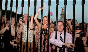 The crowd cheers as the birth notice is placed on the easel in the forecourt of Buckingham Palace to announce the birth on Monday afternoon. However, the royal family learned the news four hours before the notice went up.