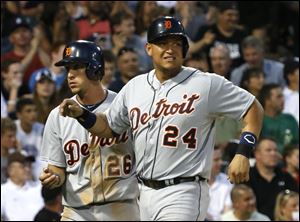 Detroit Tigers' Miguel Cabrera, right, grimaces after scoring with Hernan Perez, left, on a single by Victor Martinez, off a pitch by Chicago White Sox starting pitcher Chris Sale.