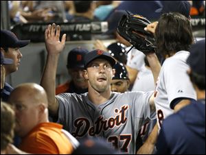 Detroit Tigers starting pitcher Max Scherzer is greeted in the dugout after pitching eight complete innings.