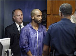 Michael Madison is brought into court for his arraignment in East Cleveland, Ohio on Monday, July 22, 2013. Madison is charged with aggravated murder in the deaths of three women found in garbage bags in the city. (AP Photo/Mark Duncan)