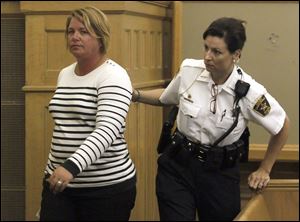Kiki Lorann is escorted out of the courtroom and into custody after sentencing for four counts of grand theft and three counts of theft for stealing thousands of dollars from school and community booster groups in Perrysburg in Wood County Common Court.