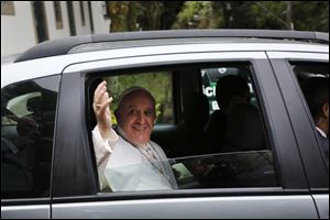 Pope Francis waves to journalists from a car as he leaves the Sumare residency on his way to the Aparecida basilica for a mass, in Rio de Janeiro, Brazil today.