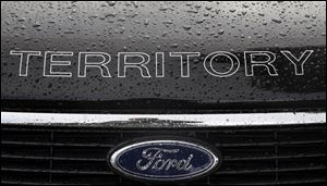 In this Thursday, May 23, 2013, photo, rain falls on a car at a Ford dealership in Sydney, Australia. Ford Motor Co. reports quarterly earnings on Wednesday, July 24, 2013. (AP Photo/Rick Rycroft)