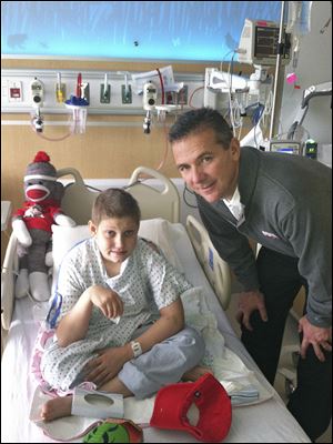 Ohio State coach Urban Meyer visited Buckeye football fan Grant Reed in December, 2012, in a Columbus hospital. Grant named his can­cer ‘Mich­i­gan’ and eventually beat the dis­ease.