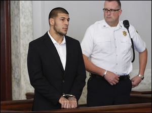 Former New England Patriots NFL football tight end Aaron Hernandez, left, appears at Attleboro District Court on Wednesday in Attleboro, Mass.