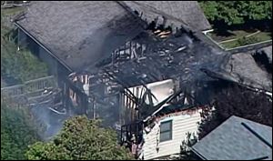 Smoke rises from a house in Columbus, Ind., after a small plane crashed into the home injuring two people who were on the plane. A woman who lives in the house and was home at the time of the crash was not injured.