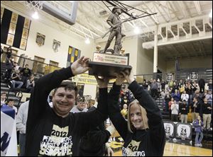 Perrysburg girls soccer team co-head coaches, Jorge Diaz, left, and Margaret Bernard hoist the MaxPreps Tour of Champions trophy during a ceremony at Perrysburg High School in January.