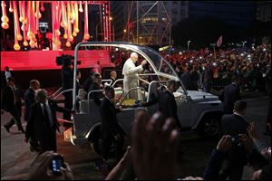 Pope Francis waves to pilgrims as he passes by the 13th station of the cross, top left, during a Stations of the Cross event, among the most popular and solemn Catholic rituals, along Copacabana beach today in Rio de Janeiro.