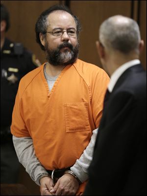 After entering the courtroom, Ariel Castro, left, looks around today in Cleveland. 