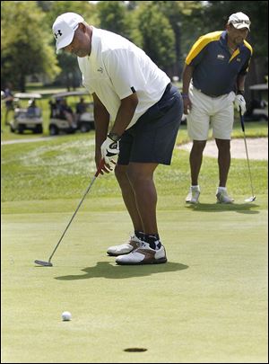 Former University of Toledo tight end Al Baker, left, and quarterback Chuck Ealey participate in the school's annual outing at Stone Oak Golf Course.