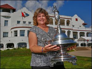 Cheri Kaintz poses with the Emery D. Potter trophy at the Toledo Yacht Club. She saw the trophy in Colorado while visiting Rolly Hassett, who later gave it Kaintz so it could return to the club.