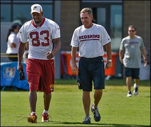 Redskins tight end Fred Davis walks with coach Mike Shanahan before practice on Friday. The Rogers grad is recovering from an Achilles injury.