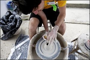 UT senior Taylor Pasquale throws clay on a potter’s wheel during Art on the Mall on the University of Toledo campus. 