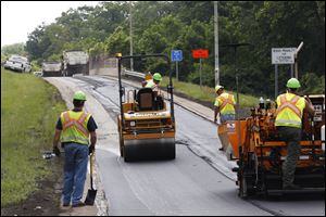 Workers with the Ohio Department of Transportation pave the entrance ramp to I-475 westbound off Secor Road in West Toledo last month. The Ohio Department of Transportation’s $1.3 million solution to long autumnal backups on I-475 at the exits closest to Westfield Franklin Park starts today.