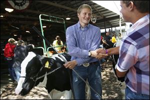 Ross Bockbrader of Stony Ridge is congratulated by another contestant, at right, after placing first in the Wood County Junior Fair Senior Dairy Beef Feeder Showman-ship. The competition was held Tuesday at the county fair-grounds in Bowling Green, where the fair continues through Sunday. 