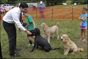 Director of Life Insurance Tyler Horning tosses a treat to his dog Otto, right.