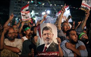 Supporters of Egypt's ousted President Mohammed Morsi chant slogans one holding a picture of Morsi with Arabic writing that reads: 