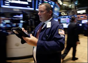 This July 29, 2013 photo, Trader Michael Conlon rushes across the floor of the New York Stock Exchange.  U.S. stock futures rose modestly Tuesday, July 30, 2013, with most investors taking a wait-and-see approach ahead of a two-day Fed policy meeting.