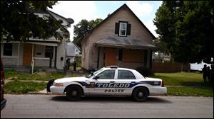 Authorities gather at 438 E. Streicher Street in North Toledo where a body was found in the basement.