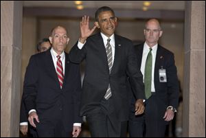 President Obama waves as he arrives on Capitol Hill in Washington, today to meet with the House Democratic Caucus. 