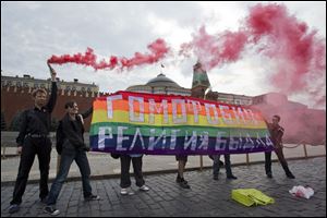 Gay rights activists hold a banner reading 'Homophobia - the religion of bullies' during their action in protest at Red Square in Moscow, Russia, July 14.