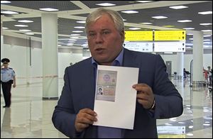Russian lawyer Anatoly Kucherena shows a temporary document to allow Edward Snowden cross the border into Russia.