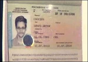 In this image taken form Russia24 TV channel, Russian lawyer Anatoly Kucherena shows Edward Snowden's  temporary document while speaking to the media after visiting the NSA leaker at Sheremetyevo airport outside Moscow, Russia.