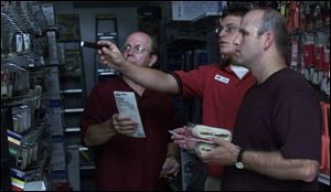 On Aug. 14, 2003, Harvey Schmidt, of Schmidt & Sons Pharmacy in Dundee, left, Ace Hardware store employee Ryan Williams, and Troy Briggs of United Bank and Trust, scrounge for phone cords. Three seconds after Toledo went dark at 34 seconds after 4:10 p.m., Detroit and southeast Michigan went dark.