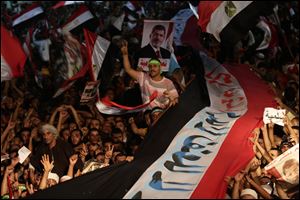 Supporters of Egypt's ousted President Mohammed Morsi  hold a large Egyptian national flag as chant slogans against Egyptian Defense Minister Gen. Abdel-Fattah el-Sissi outside Rabaah al-Adawiya mosque.