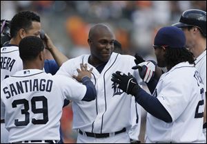 Tigers outfielder Torii Hunter is mobbed by teammates. Hunter’s line drive to left-center field in the 12th inning gave the Tigers a 3-2 victory over the White Sox on Sunday, stretching Detroit’s winning streak to eight games and Chicago White Sox’s losing streak to 10.