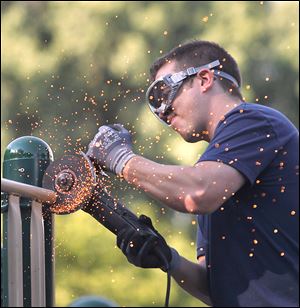 BP-Husky worker Dave Simons saws off a steel railing from the playground at Pearson Metropark in Oregon.