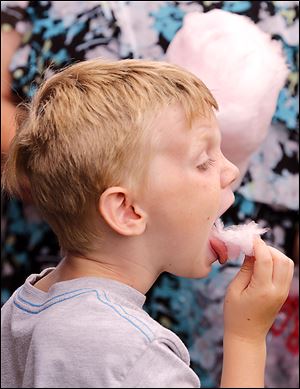Gavin Peat, 6, of Bay View, Ohio, eats cotton candy, a typical circus food group, at Monday's performance.