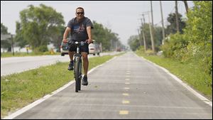 Oregon resident Alfonso Ummel rides along the recently completed Oregon Parks Bike Trail, which connects Pearson Metropark and Maumee Bay State Park.
