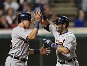 Detroit Tigers' Alex Avila, right, celebrates with Hernan Perez after Avila's three-run home run off Cleveland Indians relief pitcher Chris Perez in the ninth inning.