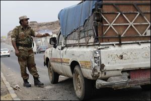 A Yemeni soldier stops a car at a checkpoint in a street leading to the U.S. embassy in Sanaa, Yemen, Sunday.