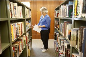 Rose Piotter, branch manager of the Deerfield Branch Library, part of the Lenawee District Library, shelves books. The library’s 0.6-mill, 10-year levy was OK’d.