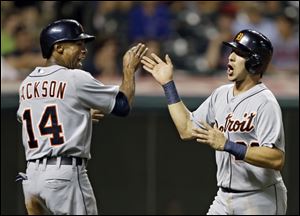 Detroit Tigers' Austin Jackson (14) and Hernan Perez celebrate after scoring on a double by Prince Fielder in the 14th inning.