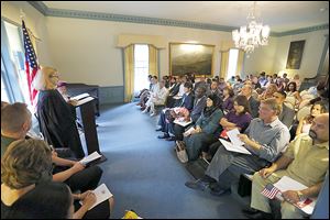 U.S. Bankruptcy Judge Mary Ann Whipple, left, presides over the naturalization ceremony for nearly two dozen people Wednesday in the Manor House.