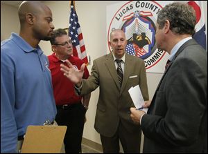 Lucas County Veterans Service officer Rick Glover, left, and Lee Armstrong, executive director of the Lucas County Veterans Service Commission, listen as Patrick Grames of Oregon explains the barriers he has faced in his VA claim to Sherrod Brown, right.